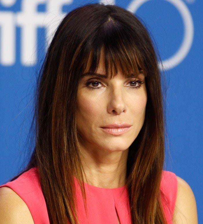 Sandra Bullock wore her long brunette hair with full bangs and soft, natural makeup