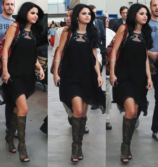 Selena Gomez steps out in a black Amen dress paired with Christian Louboutin’s intricate lace peep-toe boots, turning the streets outside El Capitan Theatre into her own runway after a surprise performance on April 18, 2012