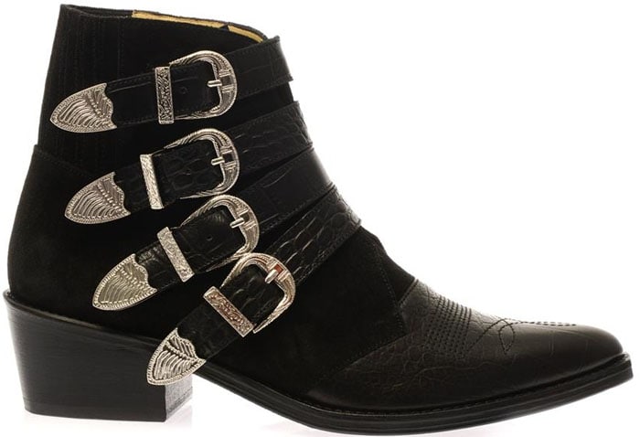 A studio product shot highlights the Toga Pulla suede-and-leather boots with engraved silver hardware and a low Cuban heel