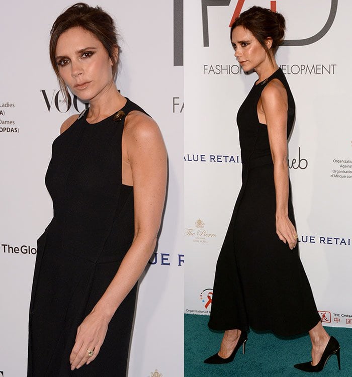 Victoria Beckham shows off her wedding ring and her arms in a sleeveless black dress accented with oversized tortoiseshell buttons