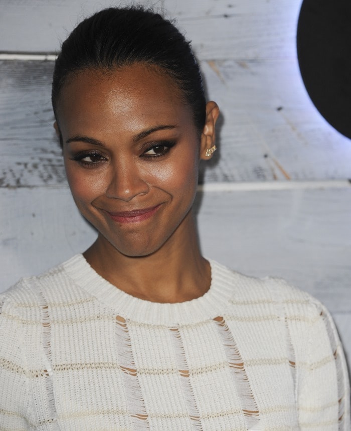 Zoe gives a subtle, warm smile while showing off the textured cutouts of her ivory knit dress