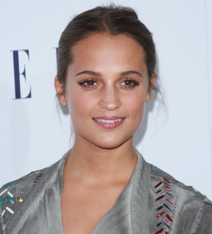 Alicia Vikander radiates natural beauty with a soft makeup look, featuring glowing skin and minimal accessories