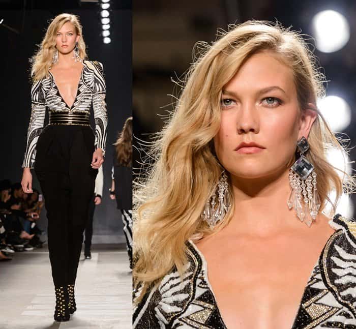 Karlie Kloss turns heads in a plunging Balmain x HM jumpsuit with bold geometric beading, cinched waist, and studded peep-toe booties that elongate her statuesque 6ft 1 height on the runway