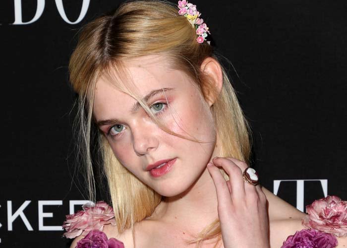 Delicate floral hair accents and natural makeup reinforce the fairy-tale femininity that defines Fanning’s red-carpet aesthetic