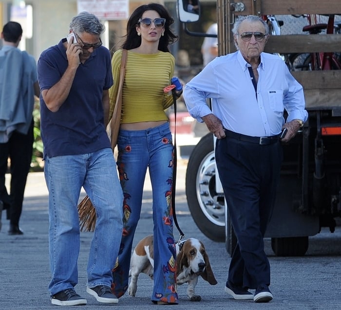 George Clooney walks with Amal Clooney and her father, Ramzi Alamuddin, during a visit to the set of Suburbicon in Los Angeles on October 20, 2016, as Amal embraces a ’70s-inspired look with embroidered bell-bottom jeans and towering platform shoes