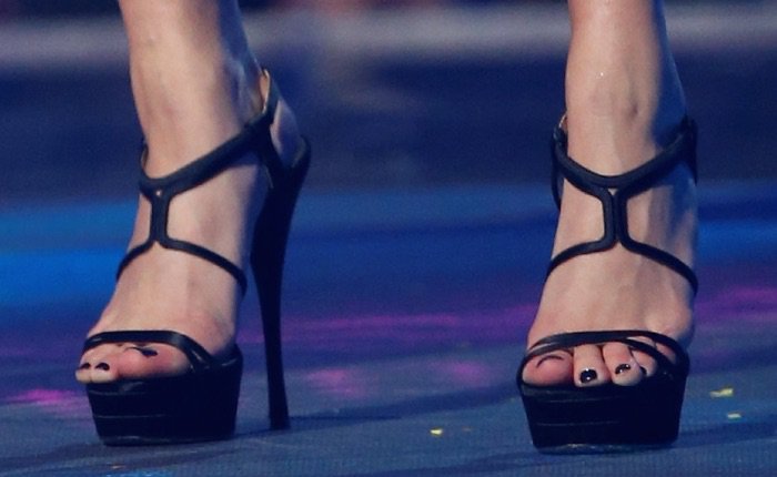 A close-up reveals the dramatic height of Hailey Baldwin’s Versace double-platform sandals, finished with slim straps and glossy black polish