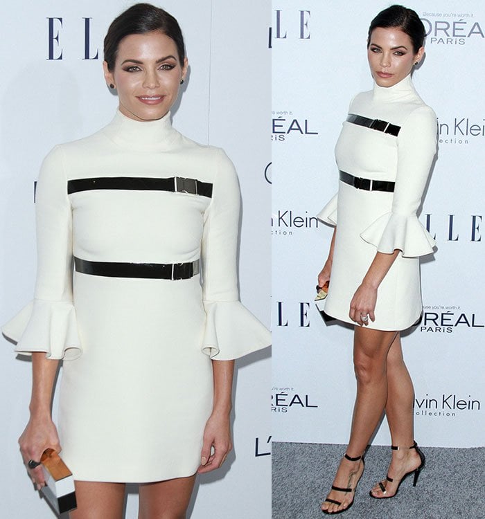 The actress showcases the dress’s sharp buckle detailing and minimalist silhouette while posing on the gray carpet