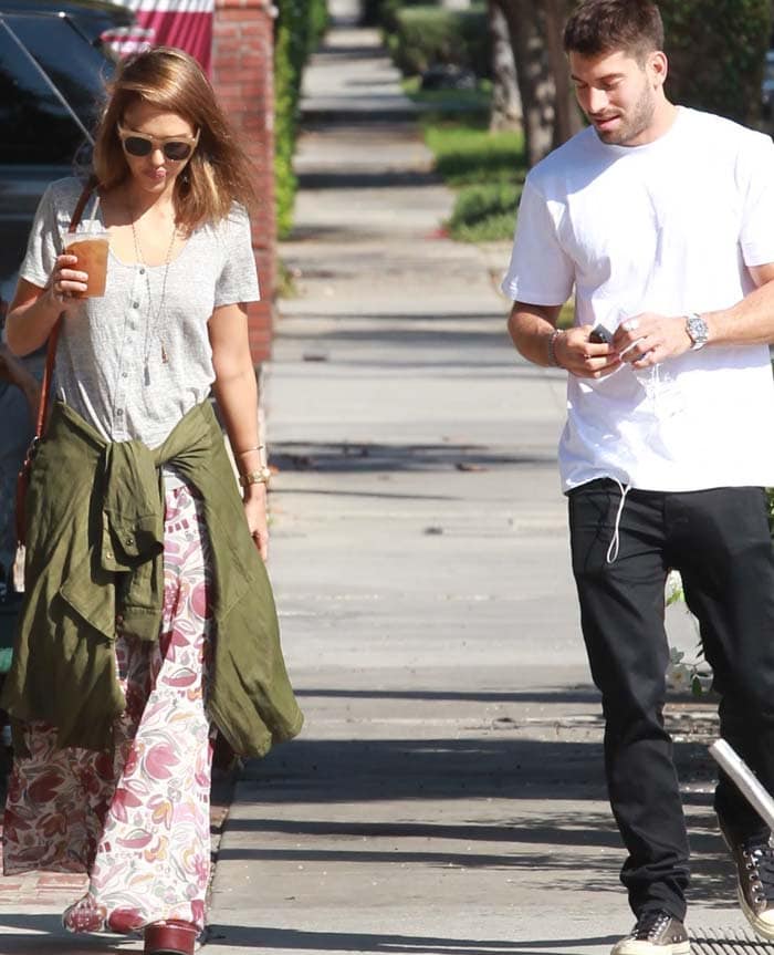 With an anorak tied around her waist and an iced coffee in hand, Jessica Alba gives her floral skirt and towering wedges an effortless off-duty feel
