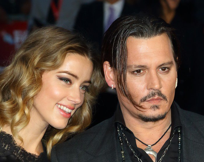 Amber Heard smiled beside Johnny Depp on the red carpet, the couple presenting a united front in coordinated black ensembles