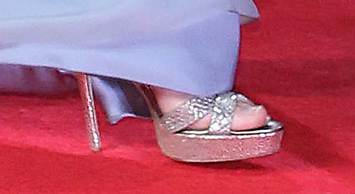 Kate Middleton completes her red carpet look with sparkling silver Jimmy Choo "Vamp" platform sandals, featuring crisscross straps and sky-high stiletto heels that add glamorous height