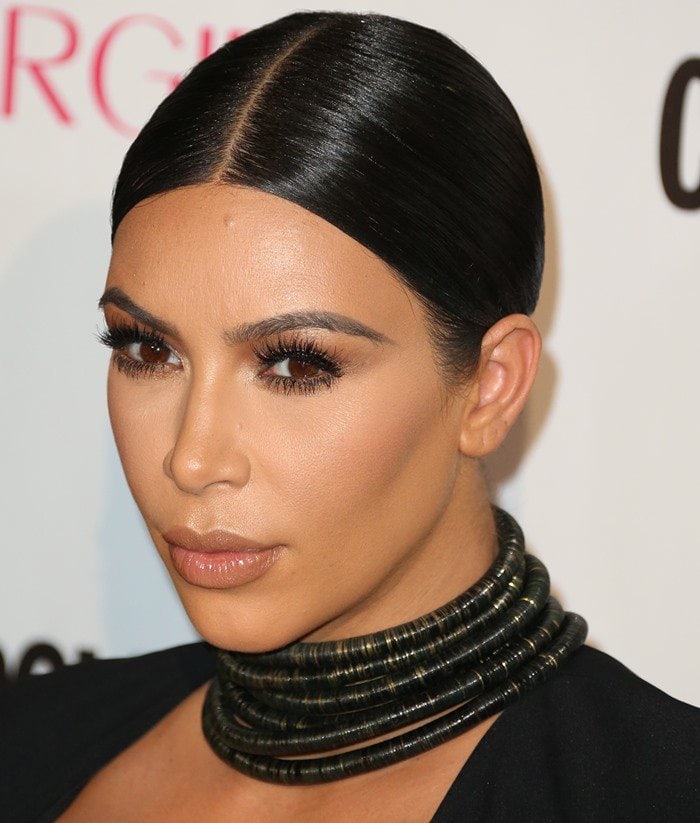 Kim Kardashian styled her sleek, center-parted hair in a low bun, drawing attention to her statement Balmain choker at Cosmopolitan’s 50th Birthday Celebration