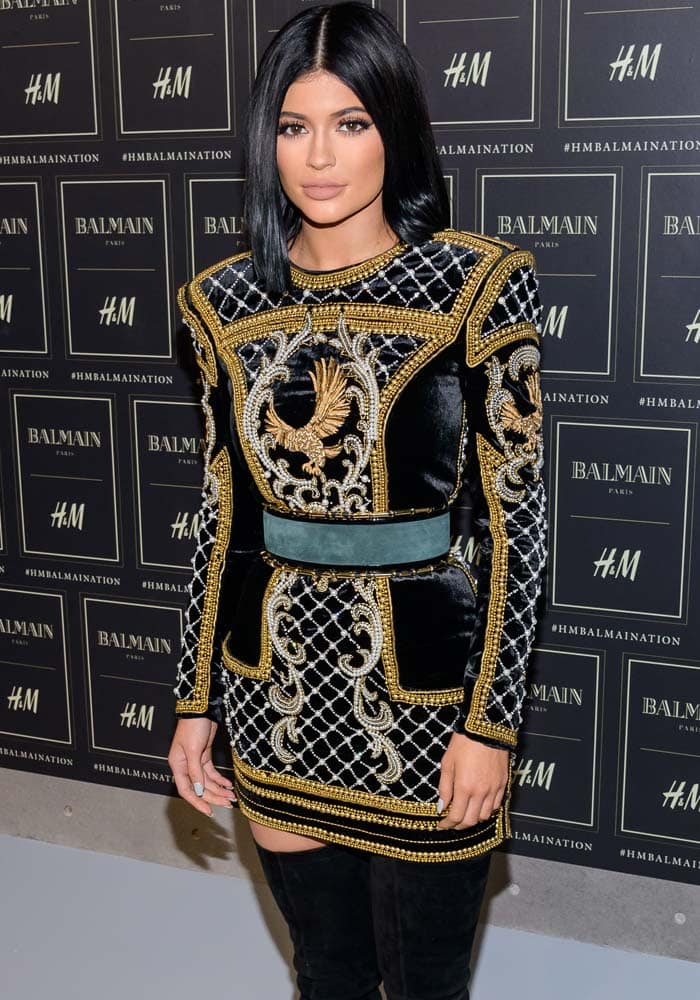 Kylie Jenner wears her dark hair with a center part at the HM x Balmain collection launch