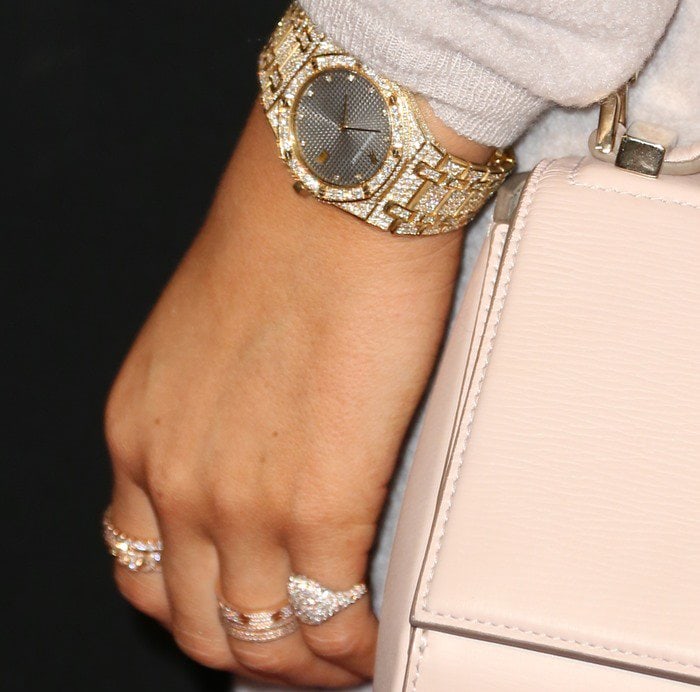 Kylie Jenner accessorized her cream-toned look with layered diamond rings, a gold watch, and a blush Givenchy “Pandora” mini shoulder bag