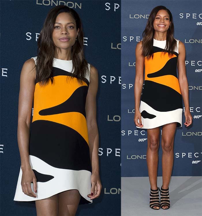 Naomie Harris brings modern Bond-girl glamour to the London Spectre photocall in a graphic Christian Dior mini dress, letting Aquazzura “Wild Side” sandals add a sharp, architectural finish to the bold color-block design
