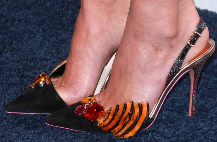 Olivia Munn showcases her feet in Sophia Webster's bold and playful 'Aria' slingback pumps, featuring intricate jewel embellishments and tiger-striped accents