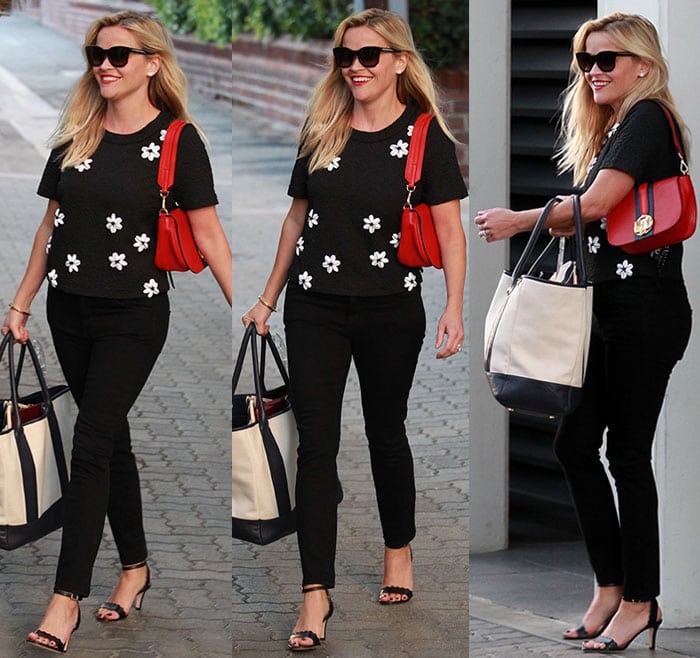 Reese Witherspoon carries a bold red handbag and a chic black-and-white tote
