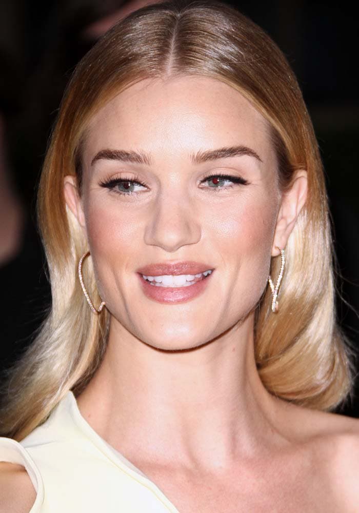 Rosie Huntington-Whiteley tucks her blonde hair behind her ears to show off her earrings