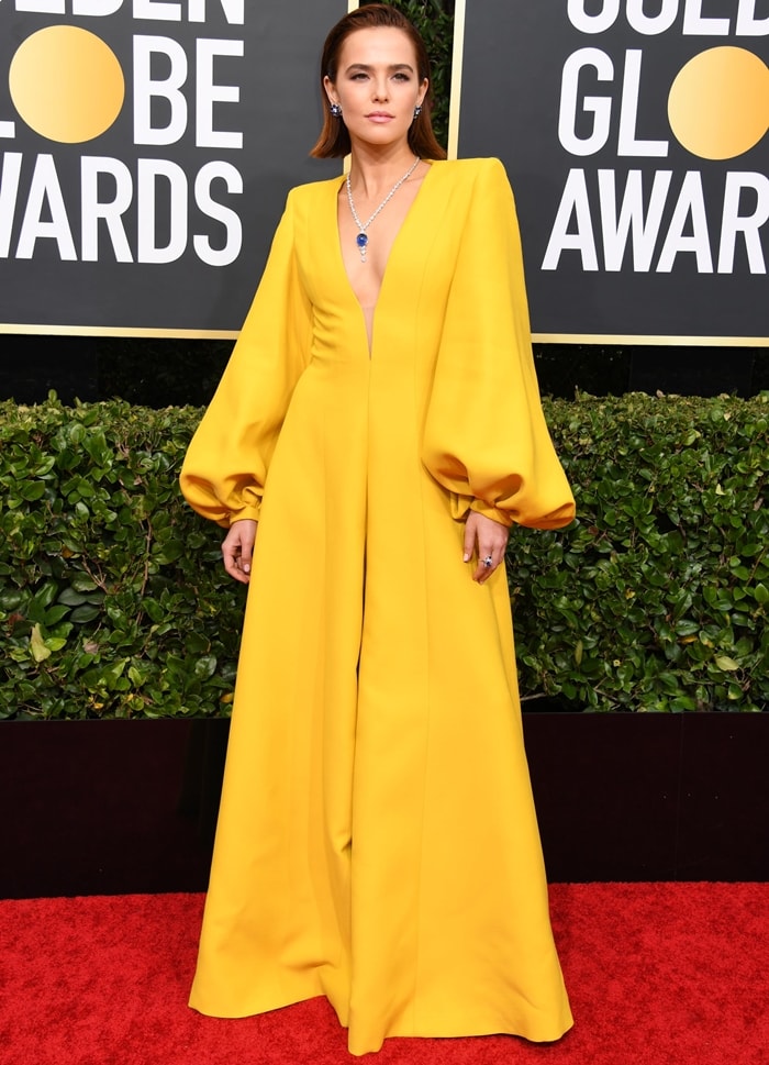 Zoey Deutch lit up the red carpet in a sunshine-yellow Fendi jumpsuit with billowing sleeves and gold Giuseppe Zanotti “Betty Knot” platforms at the 77th Annual Golden Globe Awards