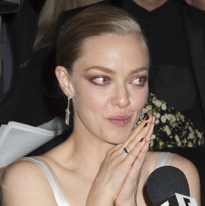 Amanda Seyfried wears her hair sleekly pulled back, accessorizing with delicate drop earrings while speaking to reporters at the CFDA/Vogue Fashion Fund Awards