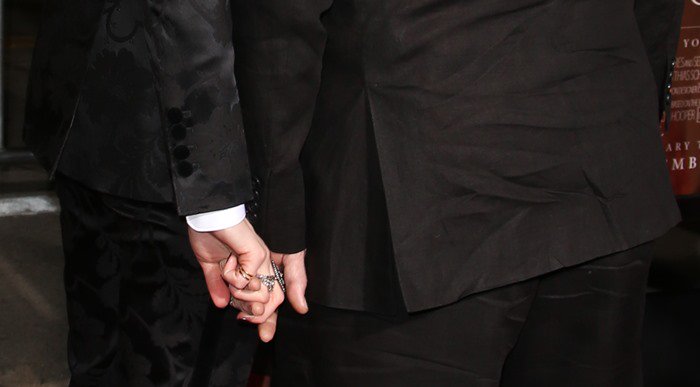 The couple shares a tender moment, holding hands as they arrive at the red carpet premiere