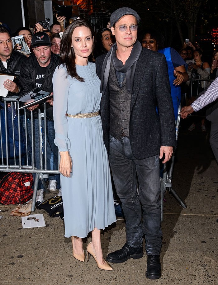 Angelina Jolie looks elegant in a blue Luisa Beccaria chiffon dress with Stuart Weitzman pumps while Brad Pitt opts for a semi-casual layered look