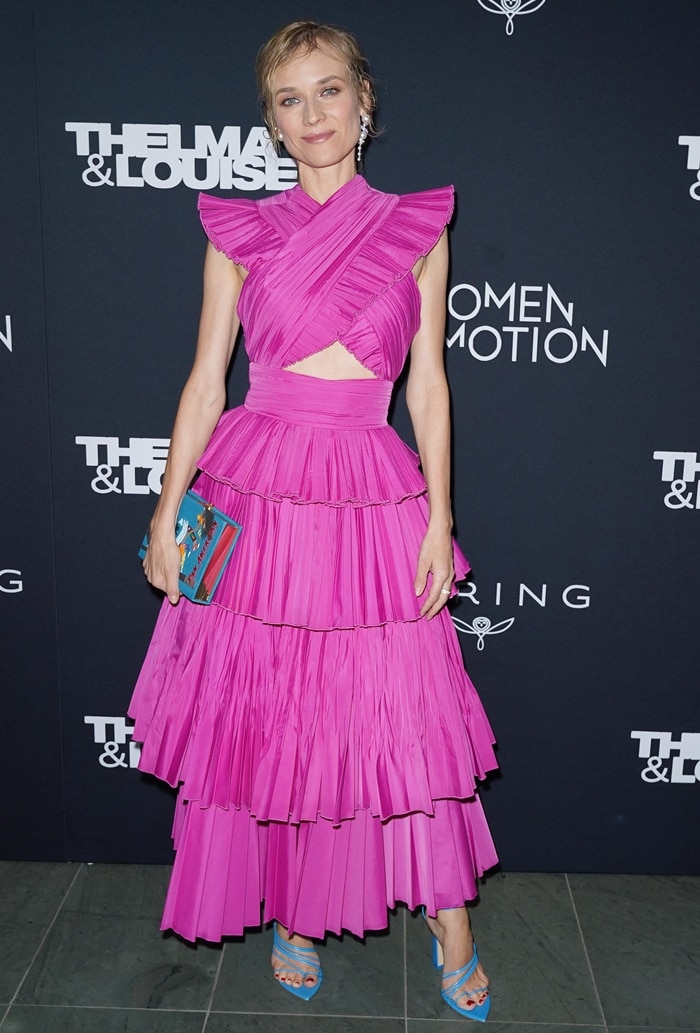The layered taffeta dress moves with architectural precision, its cross-front bodice and tiered skirt balancing volume with a sharply defined waist
