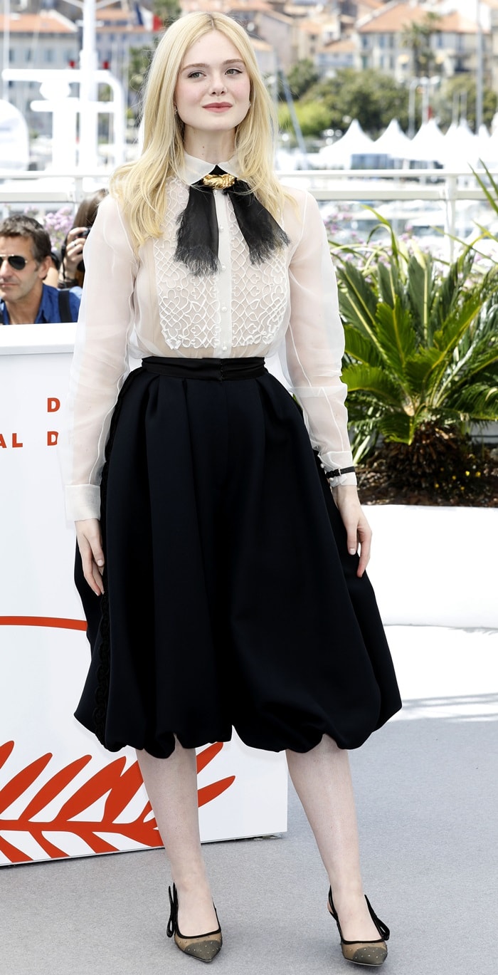 Elle Fanning grounded her monochromatic Dior Spring 2019 Haute Couture look with understated black pumps, letting the sheer embroidered blouse and sculptural pants take center stage while the classic footwear kept the Cannes jury photocall ensemble polished and restrained