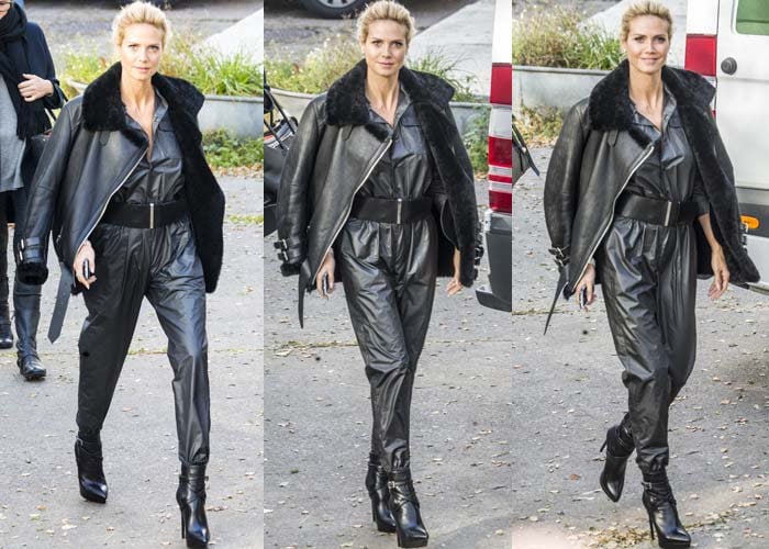 Heidi Klum wears an oversized Acne jacket and a shiny gray jumpsuit, completing her look with black Saint Laurent Janis boots