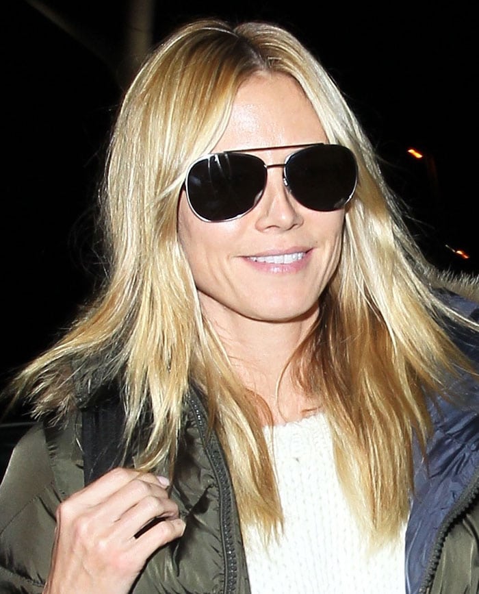 Heidi Klum touches down at Los Angeles International Airport on November 27, 2015, shielding her eyes with aviators while leaning into off-duty winter layering