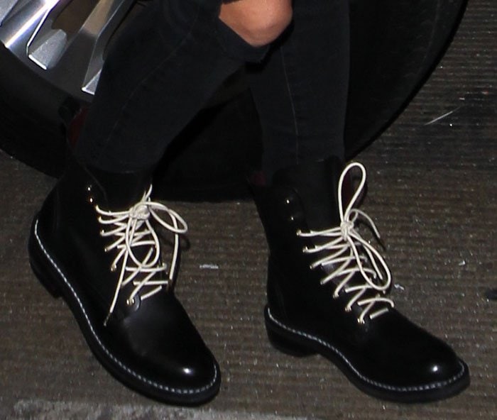 A close-up reveals the Emil boots’ defining detail—crisp white laces against glossy black leather—bringing a graphic edge to the look