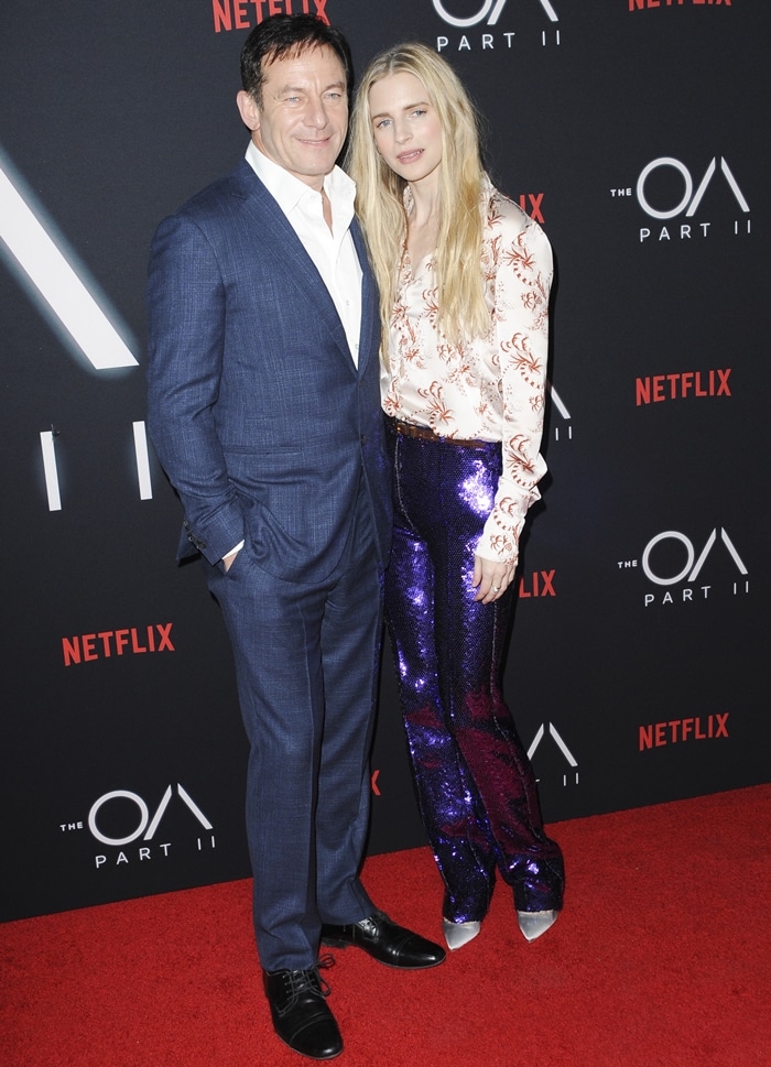 Brit Marling and Jason Isaacs pose together on the red carpet at the Netflix The OA Part II premiere, offering a rare joint appearance outside their onscreen collaboration