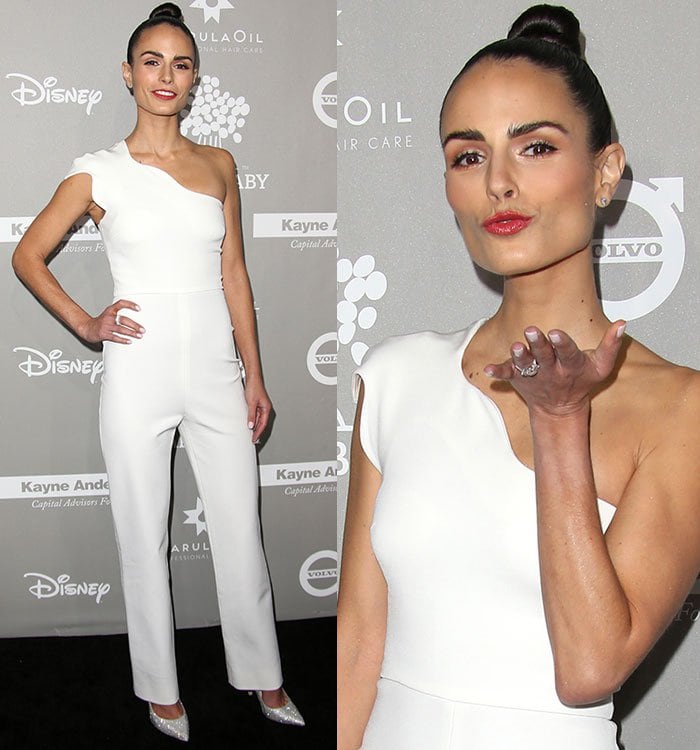 Jordana adds a playful touch to her sleek white look with a glossy pinkish-red lip and a topknot while showing off her sculptural one-shoulder neckline
