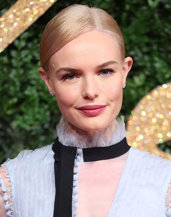 Kate Bosworth keeps her beauty understated, pairing a sleek side-parted updo and deep pink lip with the pale-blue Erdem look