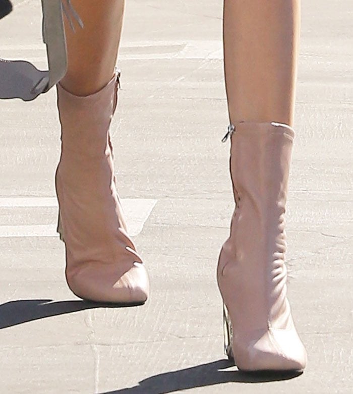 A close-up of Kendall Jenner’s powder-pink Acne Studios “Odessa” boots highlights the rounded toes, soft leather finish, and distinctive crumpled silver metal heels