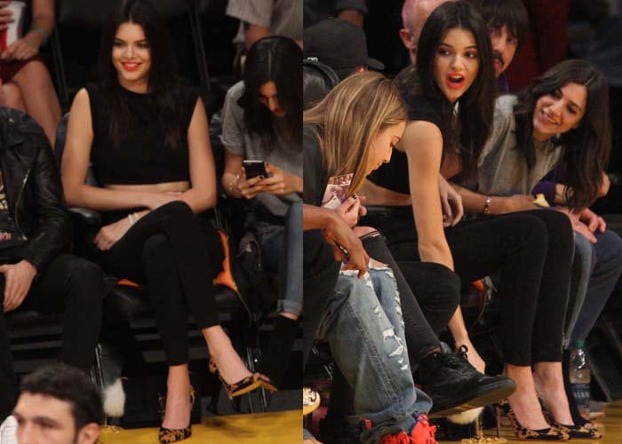 Kendall Jenner watches a basketball game in a black crop top-and-pants combo