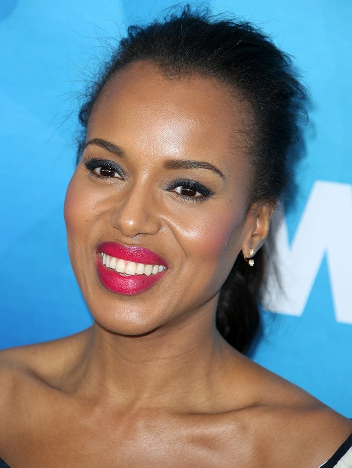 A sleek ponytail, luminous makeup, and vivid pink lipstick add a sharp pop of color to Kerry Washington’s monochrome Stylemakers look