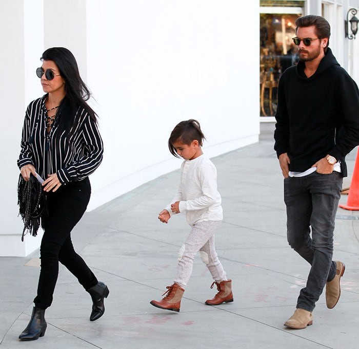 Kourtney Kardashian keeps it effortlessly chic in a striped lace-up blouse, black skinny jeans, and Saint Laurent Wyatt boots while out with Scott Disick and their son Mason