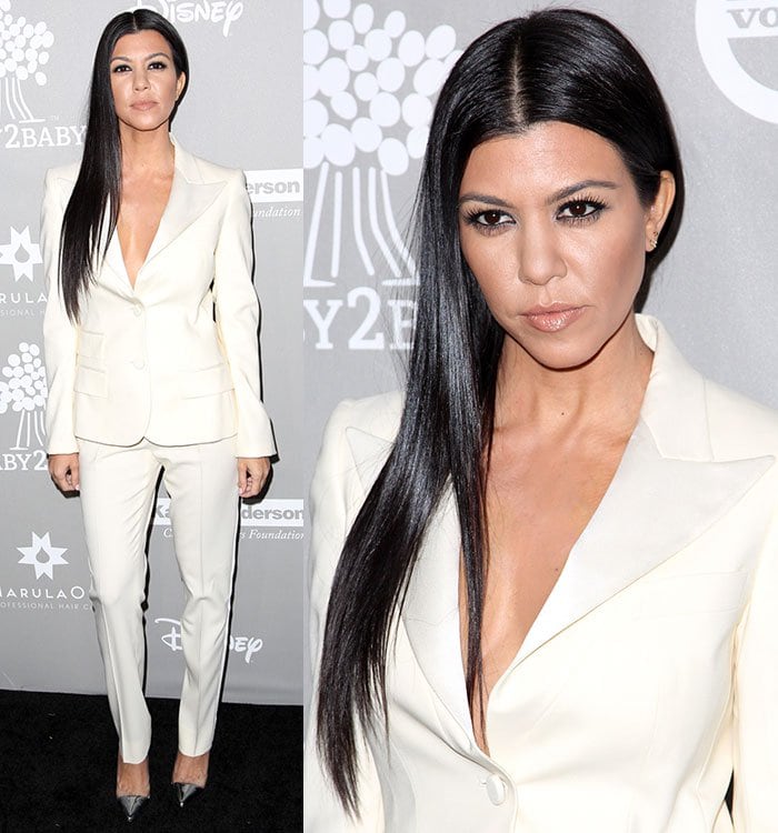 Kourtney Kardashian ditches the undergarments and shows off her cleavage in a cream pantsuit