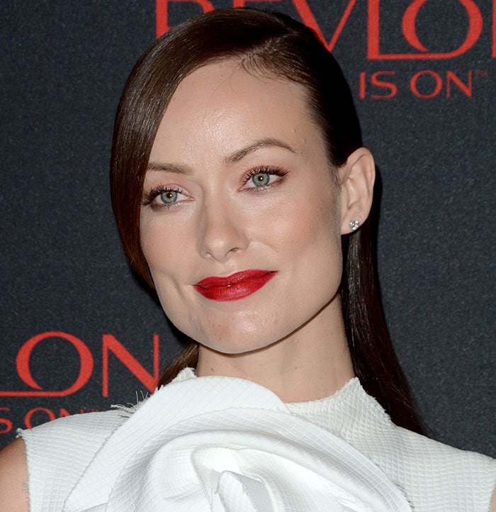 Olivia Wilde stuns with a sleek side-part hairstyle, glowing skin, and classic red lips