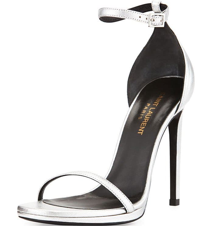 The metallic silver Saint Laurent Jane sandal showcases the house’s signature barely-there aesthetic with razor-thin straps and a sleek stiletto heel