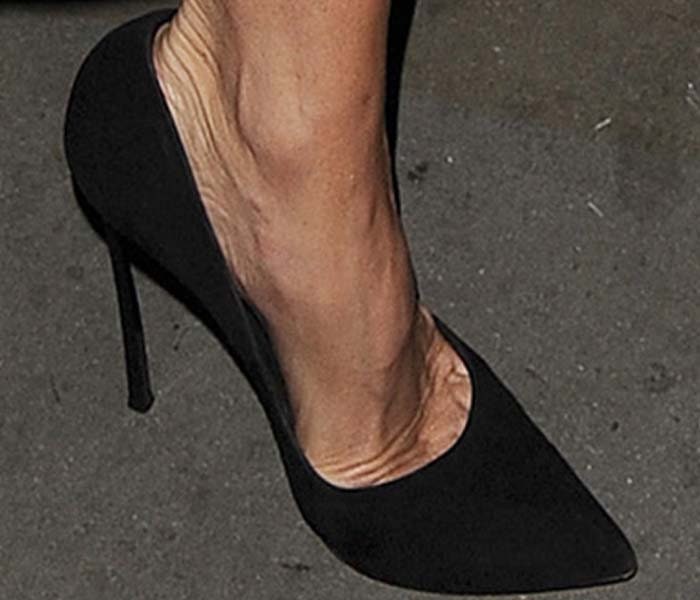 A close-up reveals the dramatic profile of Victoria Beckham’s black Casadei Blade pumps, defined by an elongated pointed toe and needle-thin stiletto heel