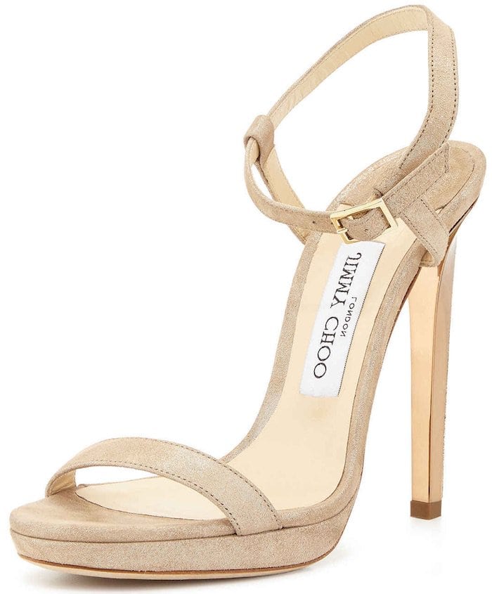 The nude suede Jimmy Choo “Claudette” sandal featured the style’s signature barely-there silhouette, combining slim straps, a delicate ankle buckle, and a sharply tapered stiletto heel that helped elongate the leg without distracting from a statement outfit