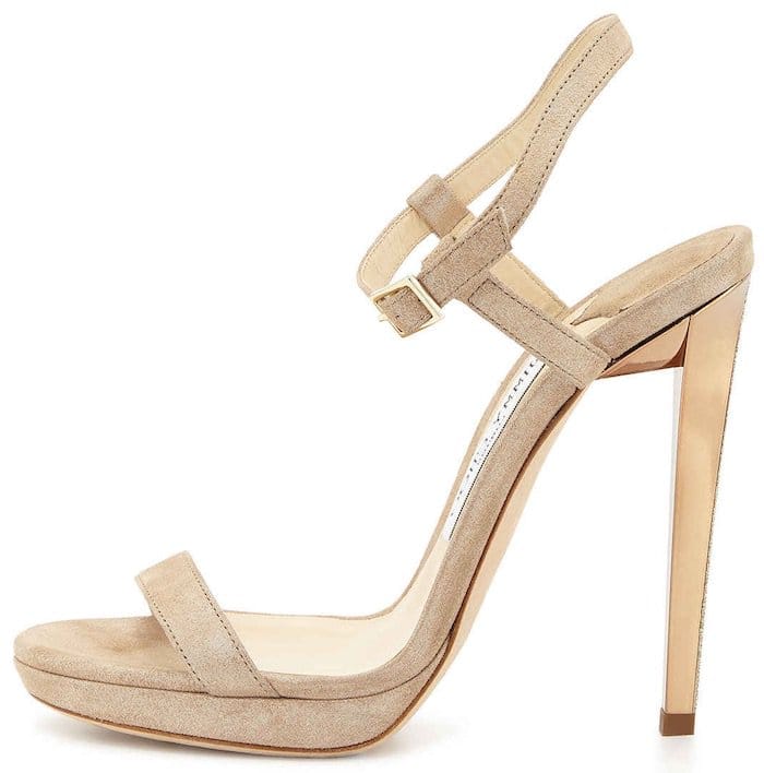 The nude suede Jimmy Choo “Claudette” sandal featured the style’s signature barely-there silhouette, combining slim straps, a delicate ankle buckle, and a sharply tapered stiletto heel that helped elongate the leg without distracting from a statement outfit