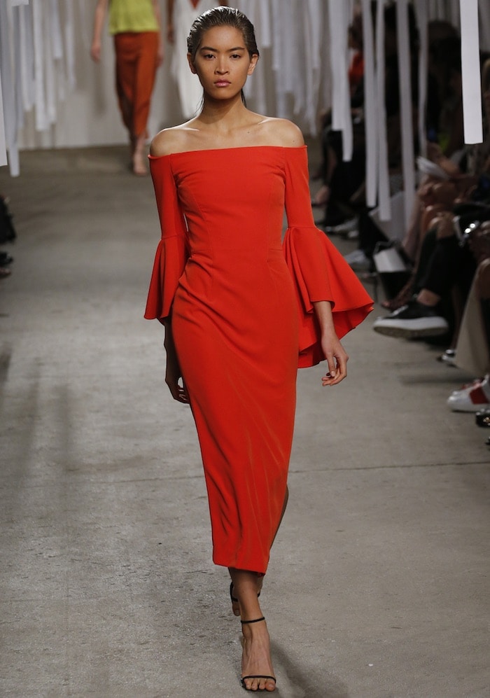 The Milly Spring 2016 runway dress balanced dramatic bell sleeves with a sleek column silhouette, giving the bold red color a clean, modern shape