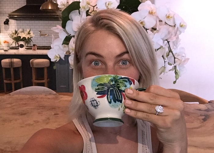 Julianne Hough playfully shows off her stunning oval diamond engagement ring while enjoying a cup of tea