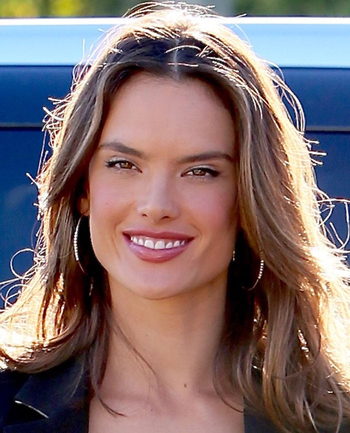Alessandra Ambrosio keeps it polished and effortless, with soft waves and gold hoops adding warmth to the sharp, graphic look