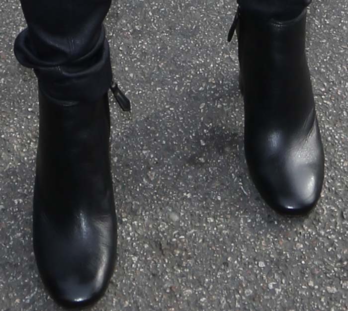 Emmy Rossum completed her volunteer look with sleek black Prada ankle boots featuring a slim heel and clean side-zip silhouette