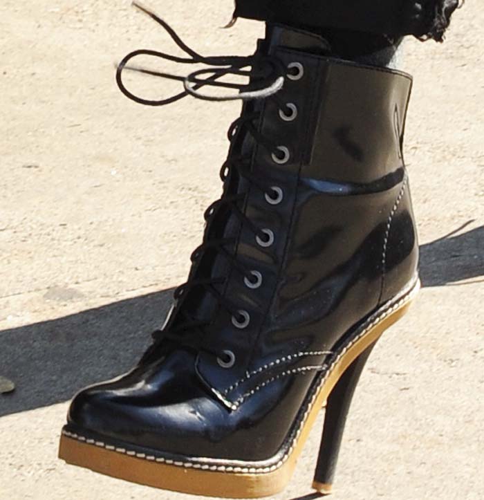 The black L.A.M.B. Nichol booties combine a lace-up combat-inspired upper with a concealed platform and towering stiletto heel, reflecting Gwen Stefani's signature blend of punk attitude and fashion-forward design