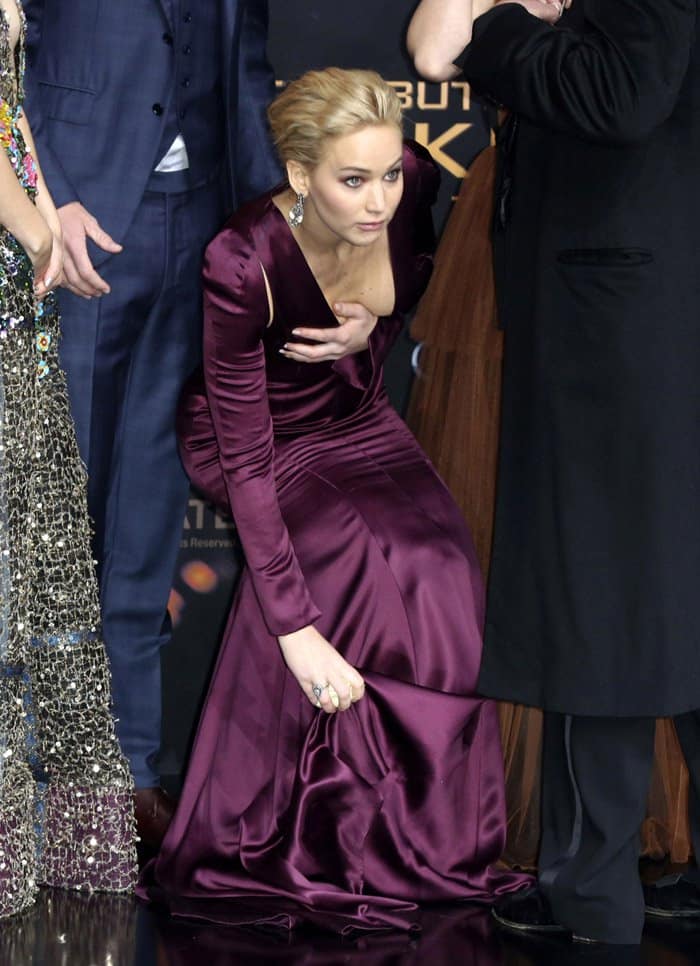 Jennifer Lawrence proves once again she's the queen of keeping it real—swiftly wrangling her Dior gown’s hem (and neckline!) like a red carpet pro at The Hunger Games: Mockingjay – Part 2 premiere