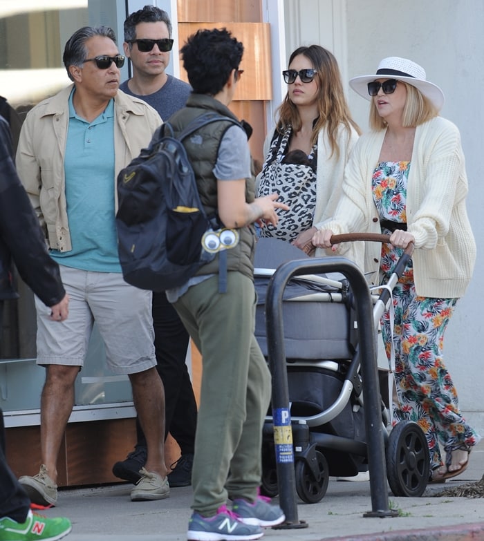 Jessica Alba keeps the look relaxed in a leopard-print maternity maxi dress layered under a cream cardigan and sandals as she steps out with her parents and husband, Cash Warren, in Los Angeles